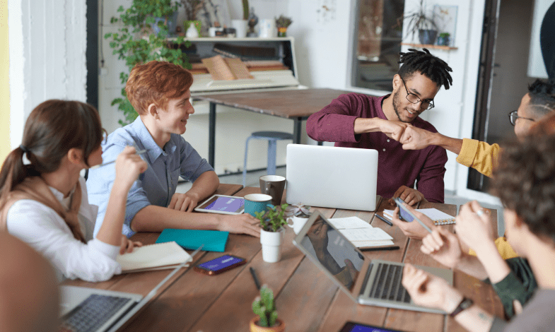 A team of people smiling sitting at computers